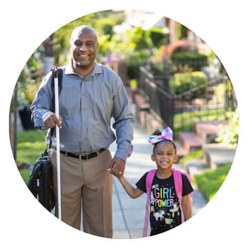 Shawn Callaway, a blind, black man walks with daughter outside, both are smiling
