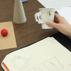 Modeling clay in the shape of a ball, a cardboard cup, a cardboard cone, and a drawing of all three objects.