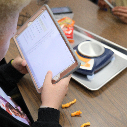 An NFB EQ student using a tablet and a scale.