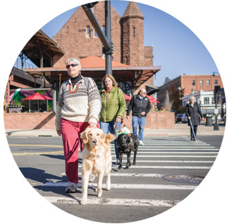 NFB members cross the street with their guide dogs.