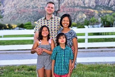 Terri Rupp with her husband and two children pose for a picture outside.