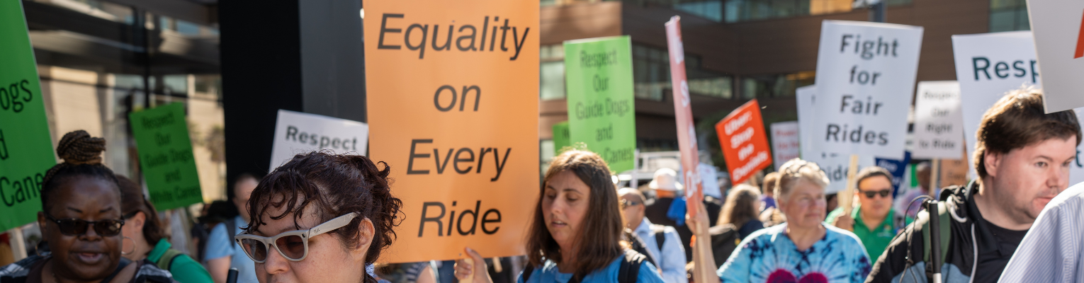 Crowd of members at Rideshare Rally. Federationist, Rachel Grider, holds a sign that says Equality on Every Ride