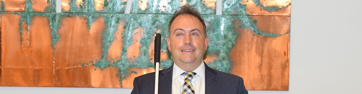 President Riccobono stands in front of a tactile painting