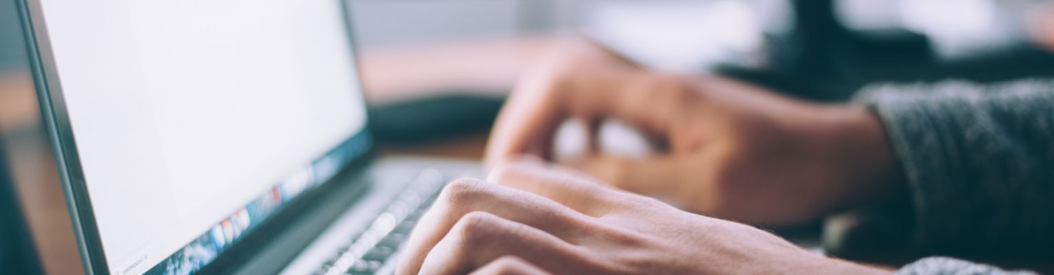 A person types on a laptop keyboard.