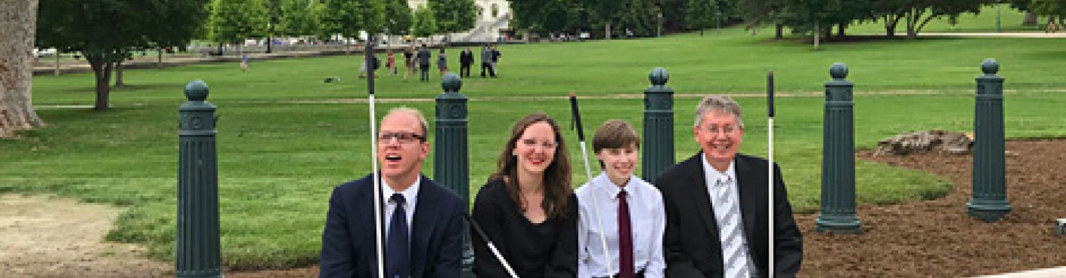 The 2018 summer interns sit outside near the United States Capitol dome with John Paré.