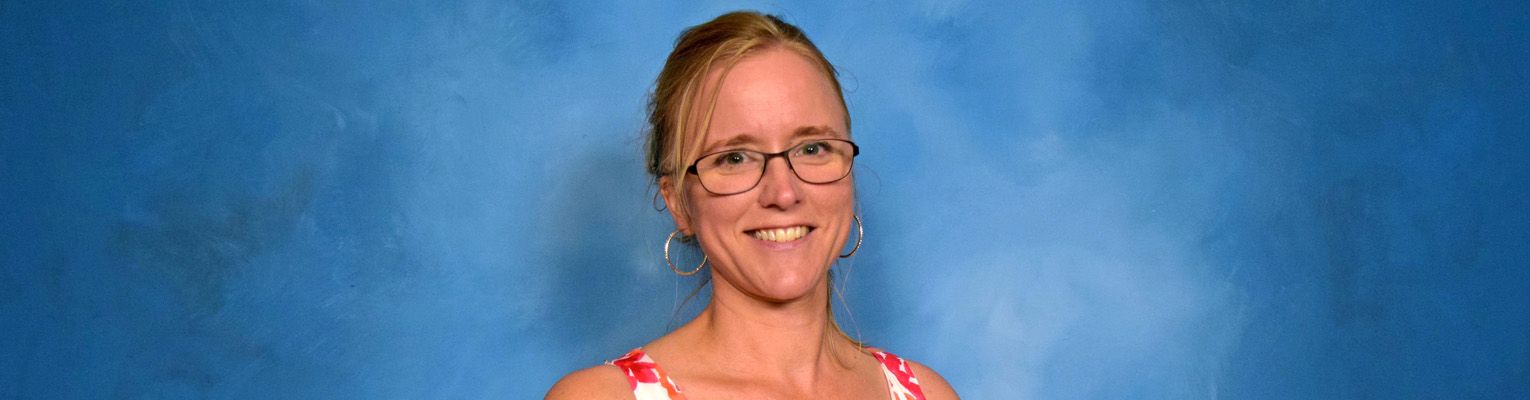 Head and shoulders shot Rachel Kuntz in front of a blue background.