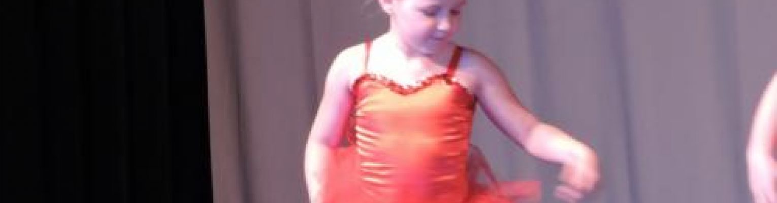 A girl on stage in a ballet costume.