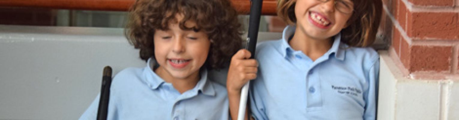 Elizabeth and Oriana Riccobono smile big for the camera while holding their canes.